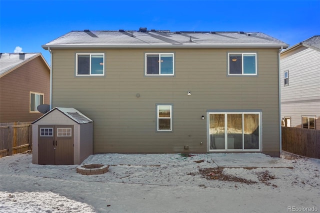 back of property with a storage shed