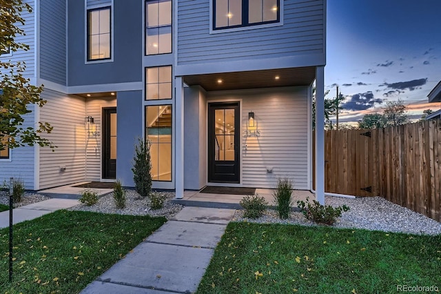 exterior entry at dusk with a lawn