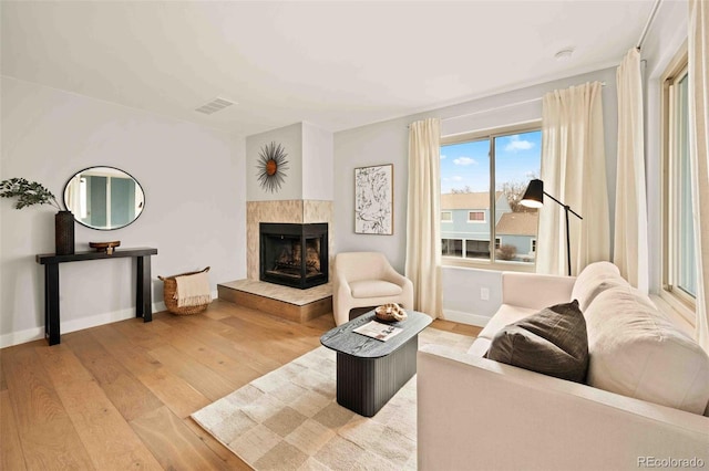 7946 Chase Cir Unit 112, Arvada, CO 80003 - living area featuring a tile fireplace, baseboards, wood finished floors, and visible vents