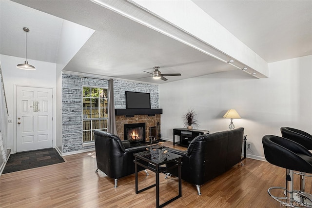 living room featuring a fireplace, ceiling fan, and hardwood / wood-style floors