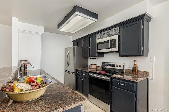 kitchen with dark stone countertops, sink, light tile patterned floors, and stainless steel appliances