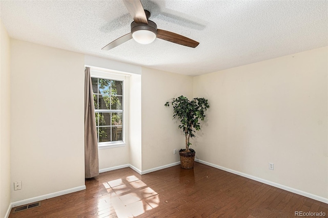 unfurnished room featuring dark hardwood / wood-style flooring and a textured ceiling