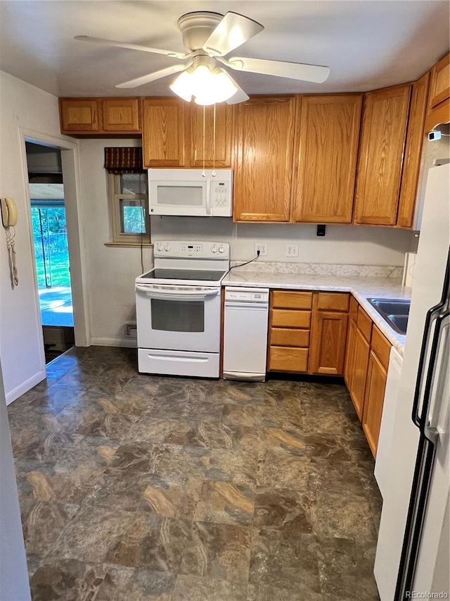 2124 S Yates St, Denver, CO 80219 - kitchen with white appliances, ceiling fan, light countertops, and brown cabinets