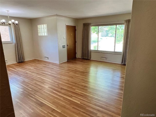 2124 S Yates St, Denver, CO 80219 - spare room featuring a chandelier, healthy amount of natural light, and wood finished floors
