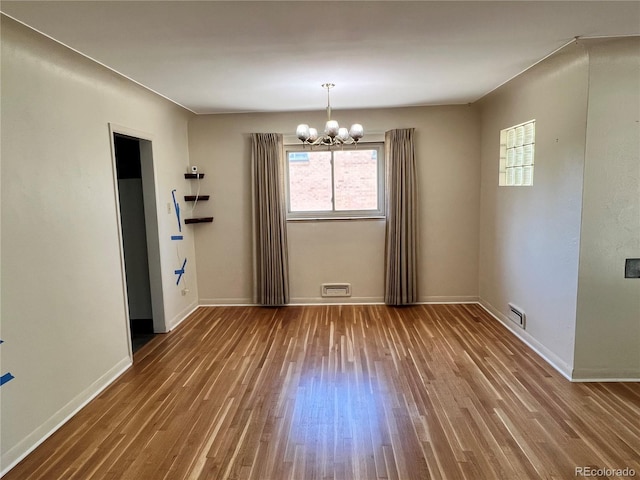 2124 S Yates St, Denver, CO 80219 - unfurnished room featuring wood finished floors, a chandelier, and baseboards