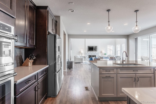 kitchen with a sink, decorative backsplash, appliances with stainless steel finishes, and light countertops