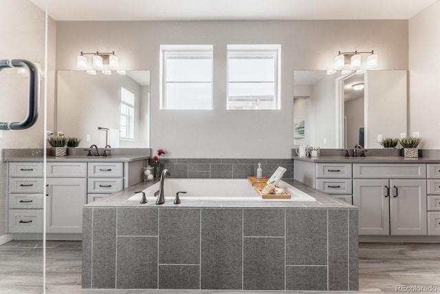 full bath with a bath and vanity