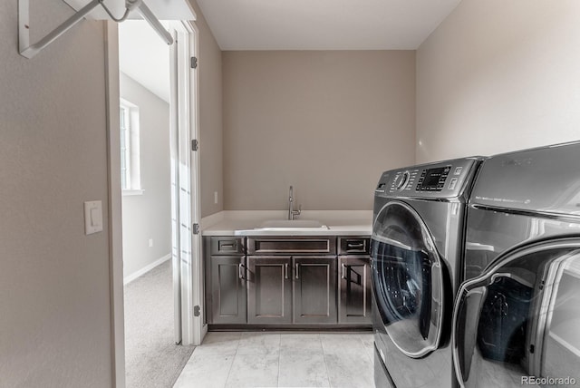 laundry area with washer and clothes dryer, cabinet space, and a sink