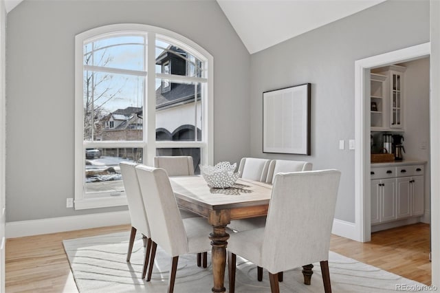 dining area featuring light hardwood / wood-style flooring and vaulted ceiling