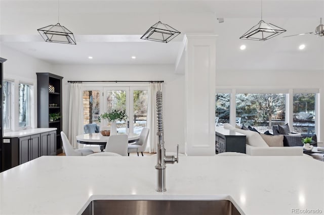 kitchen with decorative light fixtures, ceiling fan, and sink