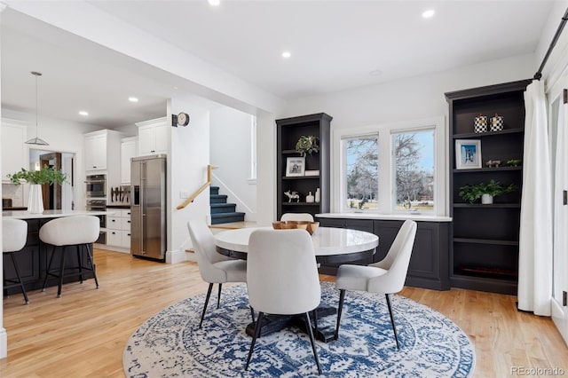 dining room with built in features and light hardwood / wood-style flooring