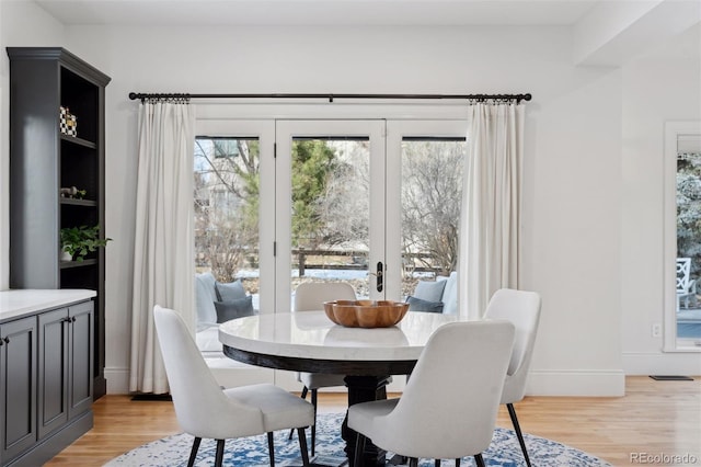 dining room with french doors and light wood-type flooring