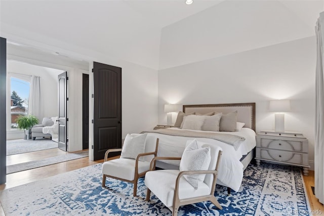 bedroom with light hardwood / wood-style flooring and lofted ceiling