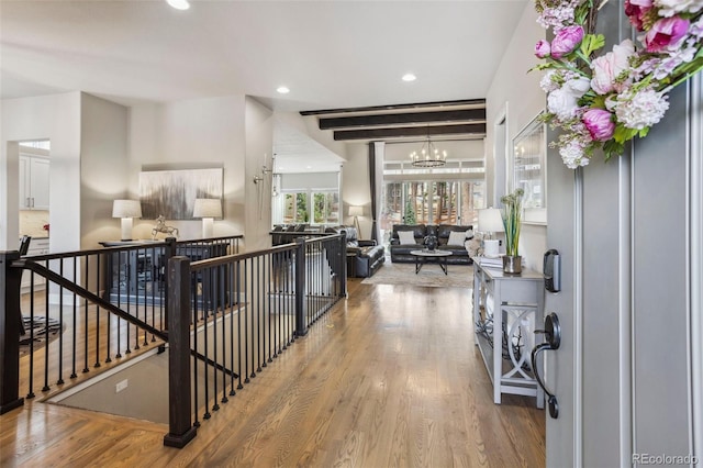 hallway featuring a chandelier, wood finished floors, an upstairs landing, and recessed lighting