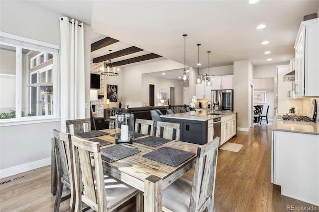 dining room with recessed lighting, a chandelier, baseboards, wood finished floors, and beamed ceiling