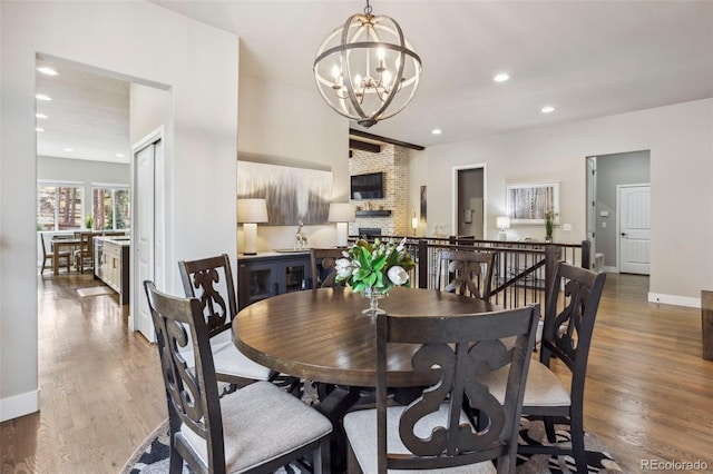 dining room featuring a chandelier, wood finished floors, recessed lighting, and baseboards