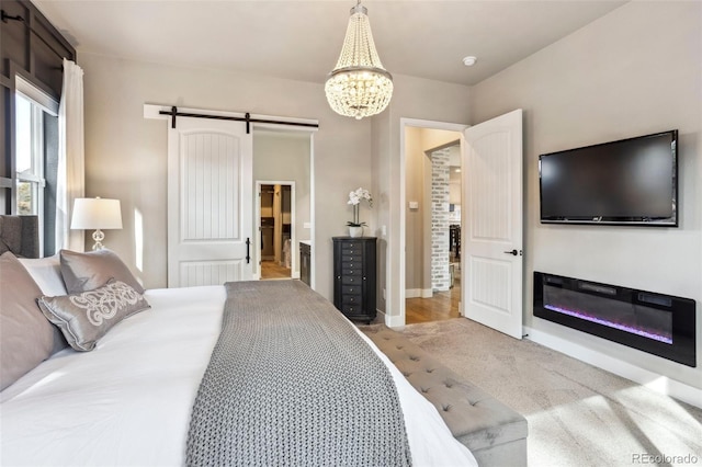 bedroom featuring a barn door, a chandelier, baseboards, and carpet floors