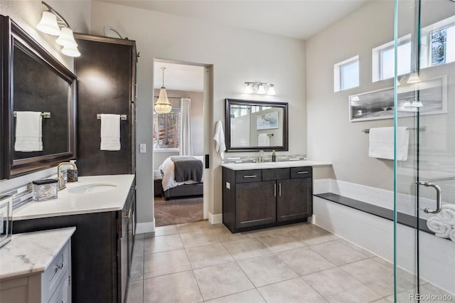 ensuite bathroom with tile patterned flooring, two vanities, and a stall shower