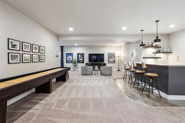 game room with wet bar, recessed lighting, baseboards, carpet flooring, and wood finished floors