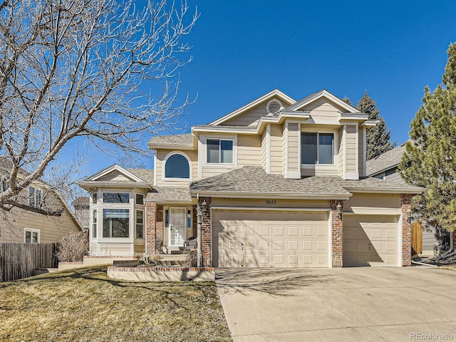 traditional-style house with concrete driveway, brick siding, an attached garage, and fence