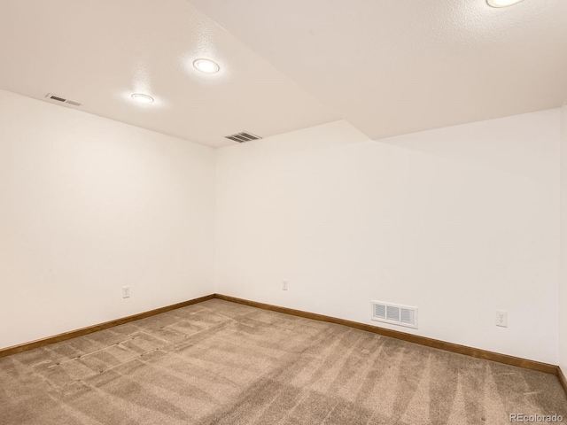 spare room with baseboards, visible vents, and light colored carpet