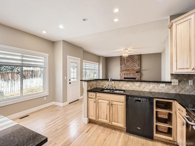 kitchen with dishwasher, a sink, light brown cabinets, and visible vents