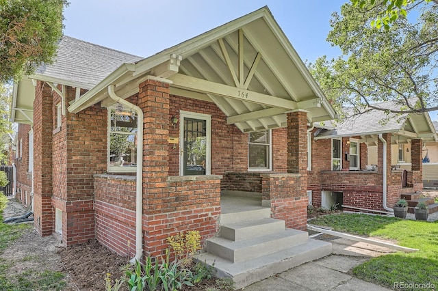 tudor-style house with a porch and brick siding