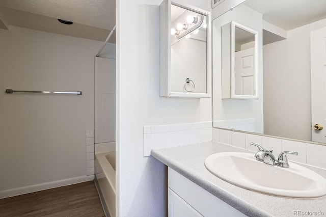 full bath with vanity, wood finished floors, baseboards, and  shower combination