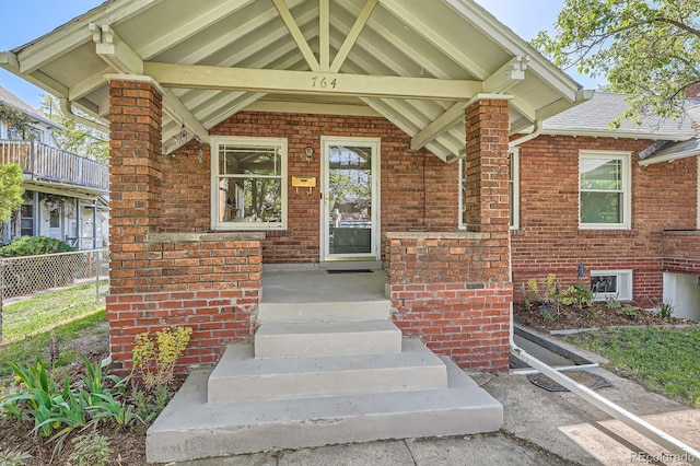 entrance to property with brick siding and fence