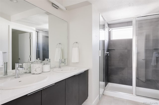 bathroom featuring tile patterned flooring, a sink, a shower stall, and double vanity