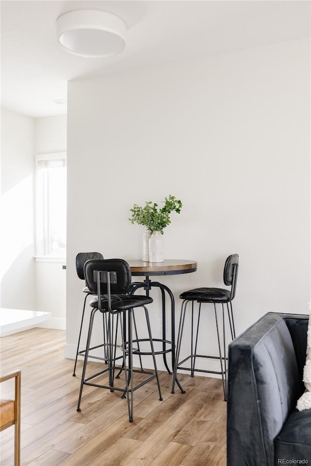 dining area with baseboards and light wood finished floors