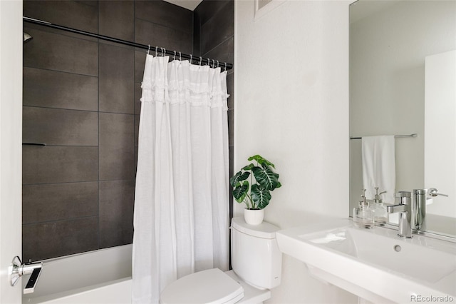 bathroom featuring shower / bath combo, a sink, and toilet