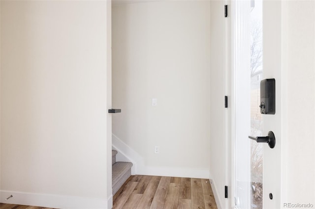 interior space featuring light wood-type flooring, baseboards, and stairs