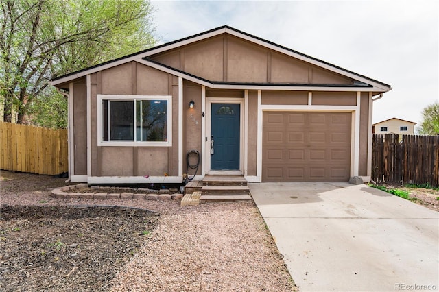 single story home featuring an attached garage, driveway, stucco siding, and fence