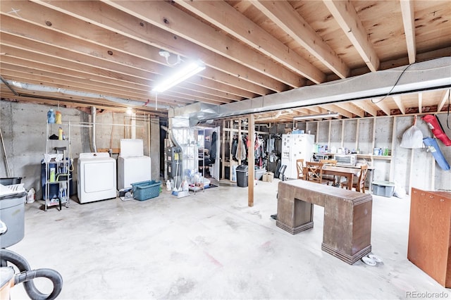 unfinished basement featuring separate washer and dryer and freestanding refrigerator