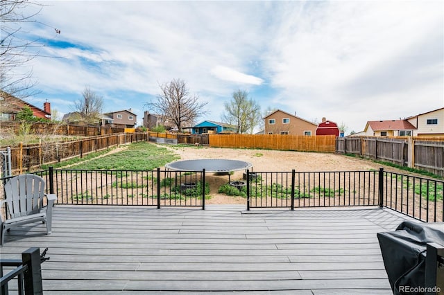 deck featuring a yard, a fenced backyard, a grill, and a residential view