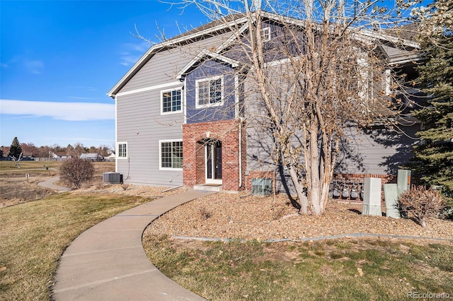 view of front property featuring central air condition unit and a front yard