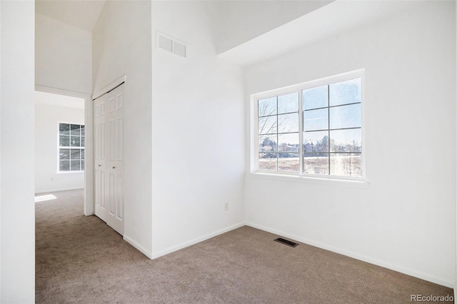 empty room featuring carpet flooring and lofted ceiling