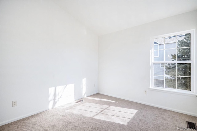 carpeted empty room with lofted ceiling