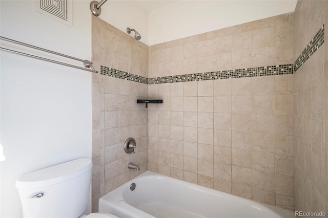 bathroom with tiled shower / bath combo and toilet