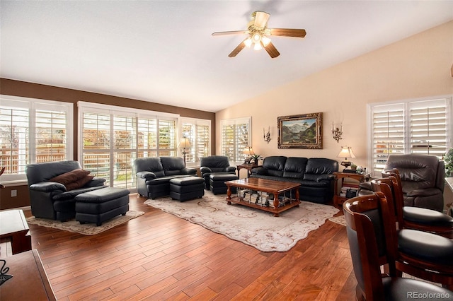 living room featuring hardwood / wood-style floors, vaulted ceiling, and ceiling fan