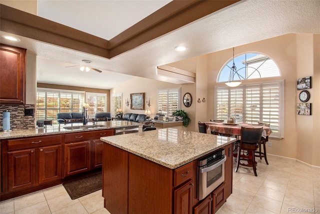 kitchen with a textured ceiling, ceiling fan, sink, and appliances with stainless steel finishes