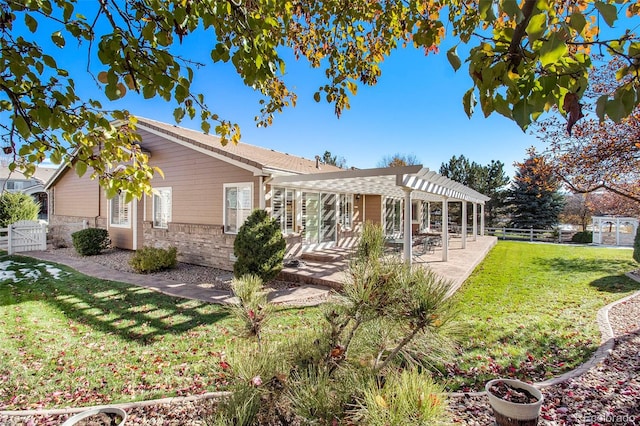 rear view of house featuring a yard, a pergola, and a patio