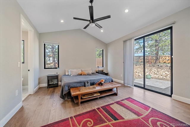 bedroom featuring multiple windows, access to outside, vaulted ceiling, and wood finished floors