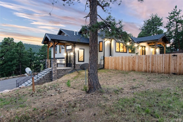24701 US Highway 40, Golden, CO 80401 - view of front facade featuring fence, stucco siding, stone siding, and roof with shingles