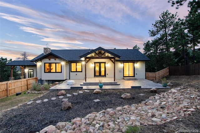 24701 US Highway 40, Golden, CO 80401 - rear view of house with stucco siding, fence, a patio area, and a chimney