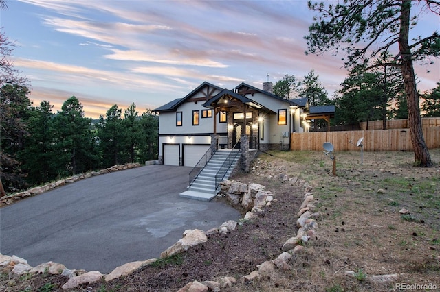 24701 US Highway 40, Golden, CO 80401 - view of front of property featuring asphalt driveway, stucco siding, a garage, fence, and stone siding