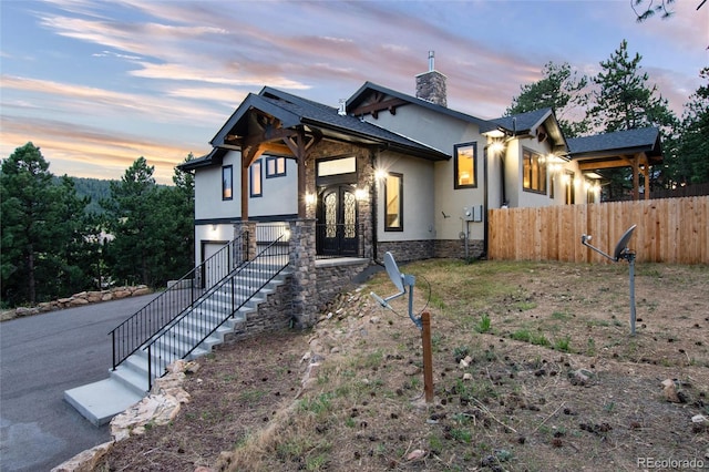24701 US Highway 40, Golden, CO 80401 - contemporary house with stucco siding, a chimney, an attached garage, french doors, and fence