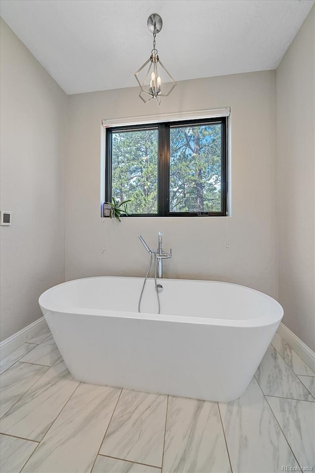 24701 US Highway 40, Golden, CO 80401 - bathroom with marble finish floors, baseboards, and a freestanding bath
