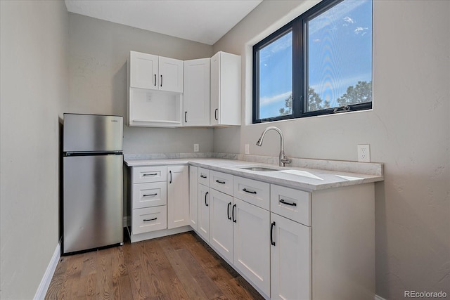 24701 US Highway 40, Golden, CO 80401 - kitchen featuring freestanding refrigerator, a sink, dark wood-style flooring, white cabinetry, and light countertops